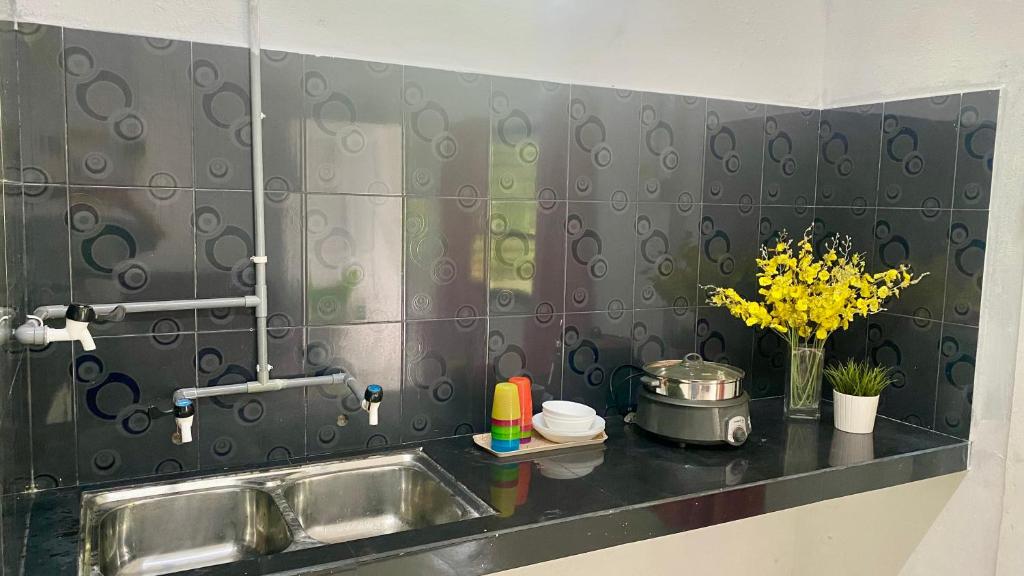 a kitchen with a sink and a counter with flowers at Homestay Bajet Rantau Panjang 
