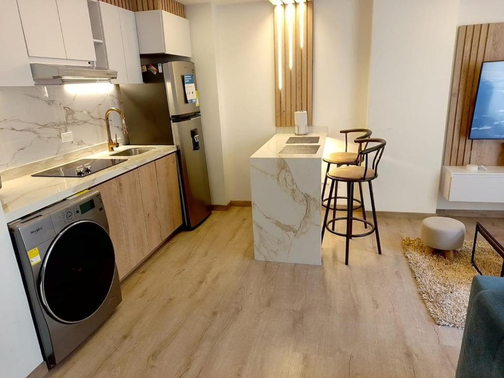 a kitchen with a sink and a washing machine in it at Modern studio in a tourist and university area in Bogotá