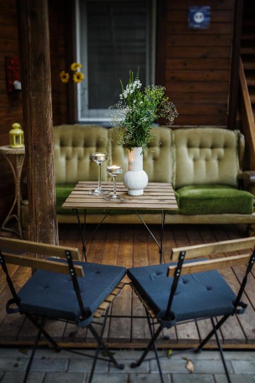 a table with two chairs and a vase with flowers at Namelis prie Magnolijos in Druskininkai