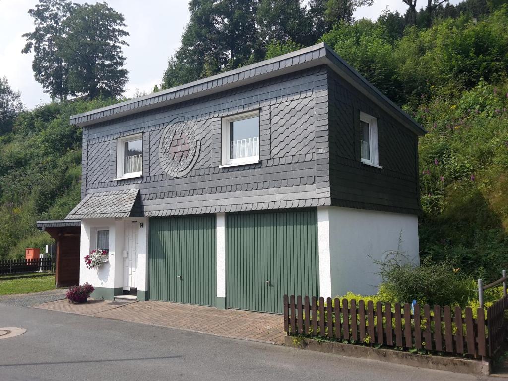 una pequeña casa con un garaje verde y blanco en Ferienwohnung Ambiente, en Winterberg