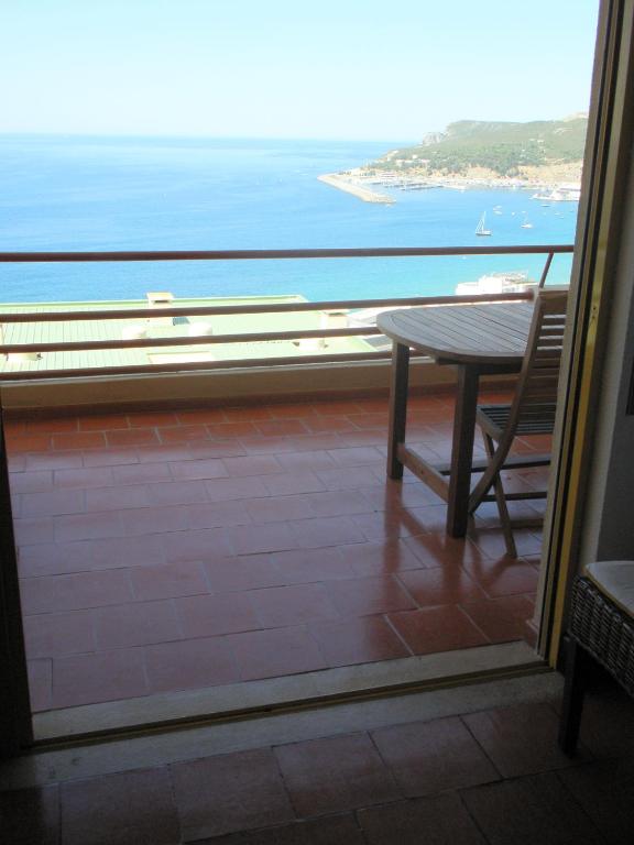 uma mesa e cadeira num quarto com vista para o oceano em Apartment over the Ocean em Sesimbra