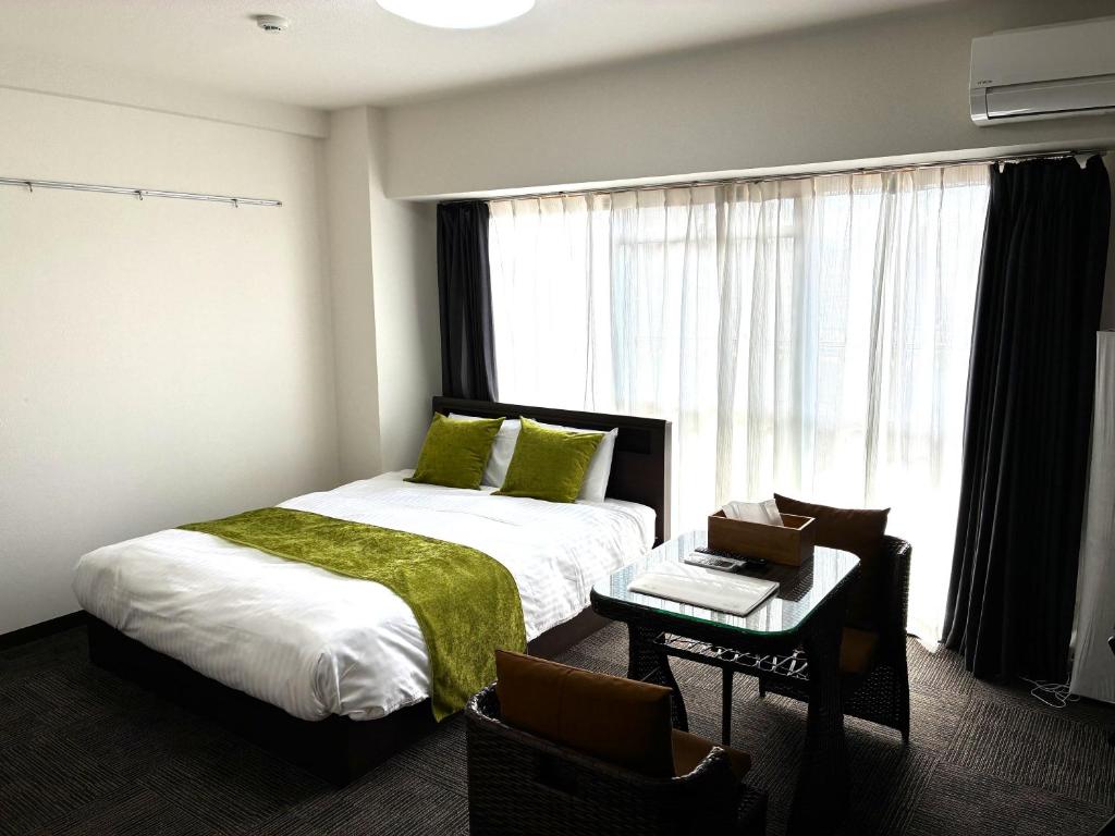 a hotel room with a bed and a window at エレガンス京町 -岡山市内中心部 路面電車の駅まで徒歩5分 のんびりステイ in Okayama