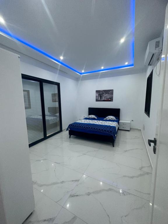 - une chambre avec un lit et une lumière bleue dans l'établissement Coquette villa, à Hammamet Sud