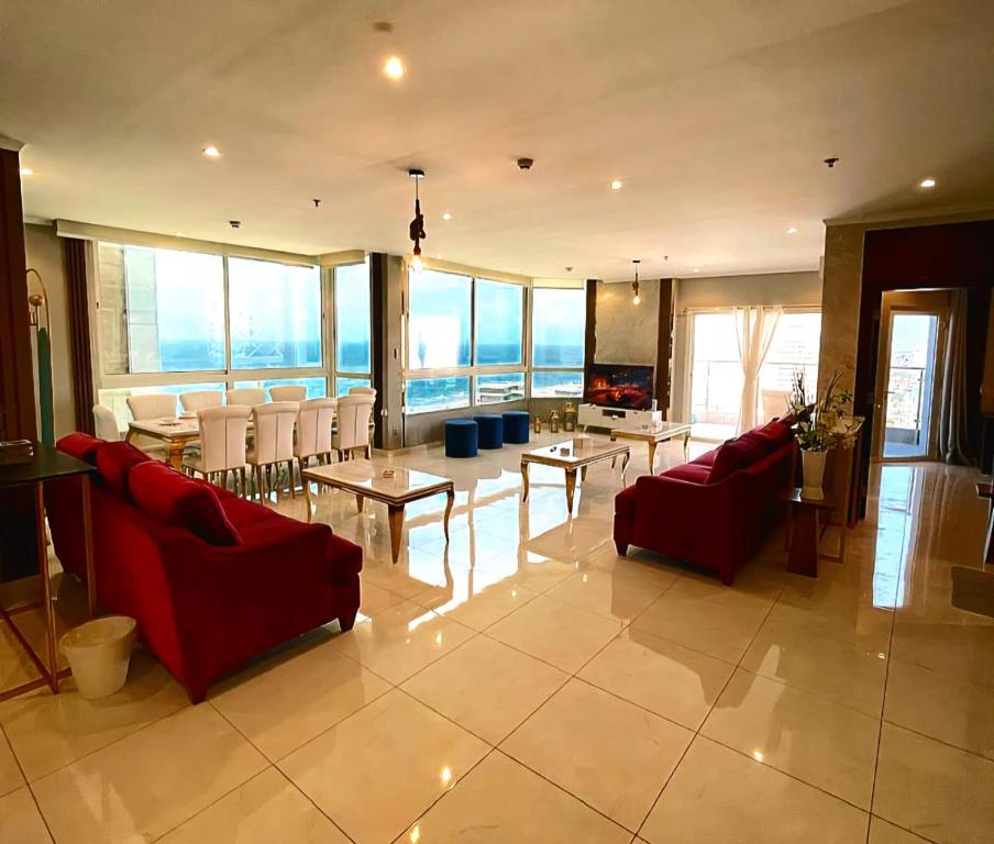 a living room with red couches and tables and windows at villa-Sea view فيلا اطلالة بحرية جار القمر in Jeddah