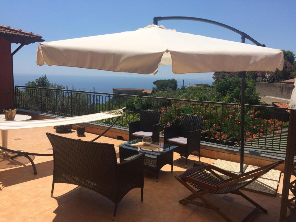 a patio with an umbrella and chairs and a table at Belvedere Piano di Sorrento in Piano di Sorrento