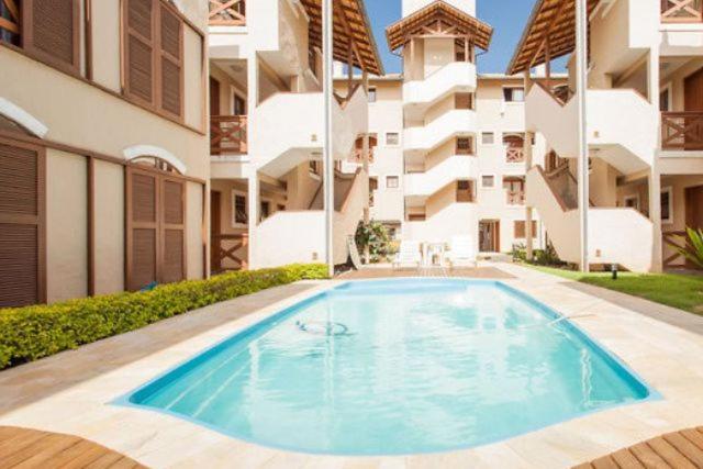 uma piscina em frente a um edifício de apartamentos em Apartamento em Residencial Riviera em Florianópolis