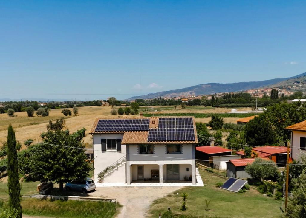 a house with solar panels on the roof at Netik Apartment Cortona - Tuscan Vineyard escape in Cortona