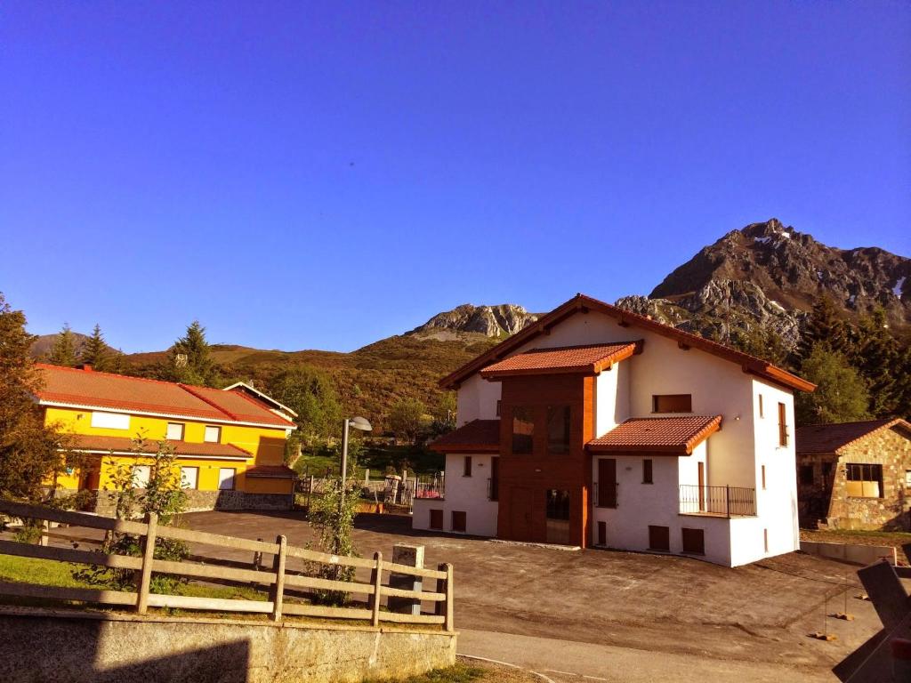 un grupo de edificios con montañas en el fondo en Complejo Hotelero La Braña, en San Isidro