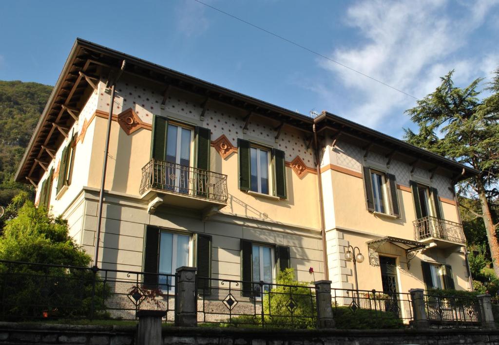 un gran edificio amarillo con balcón en Villa Ortensia, en Oliveto Lario