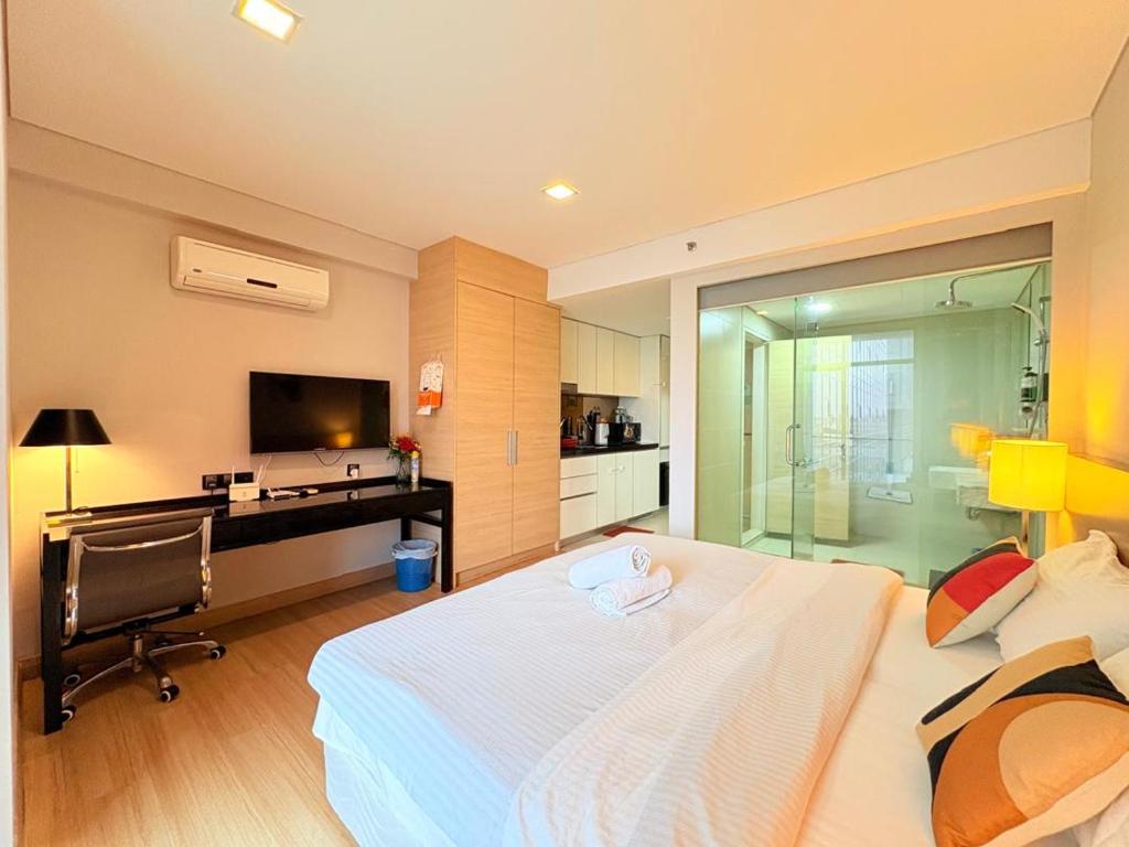 a bedroom with a large bed and a television at The Straits Residence by Koala Home in Melaka
