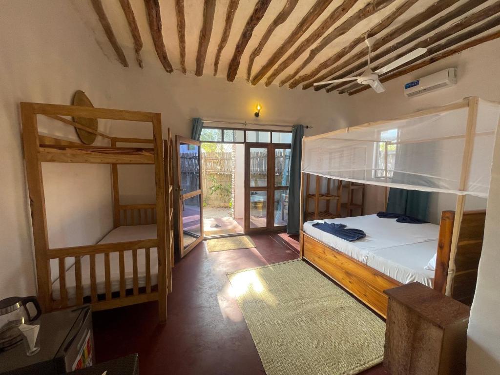 a bedroom with two bunk beds and a hallway at Zanzibar beach escape 1&2 in Bwejuu