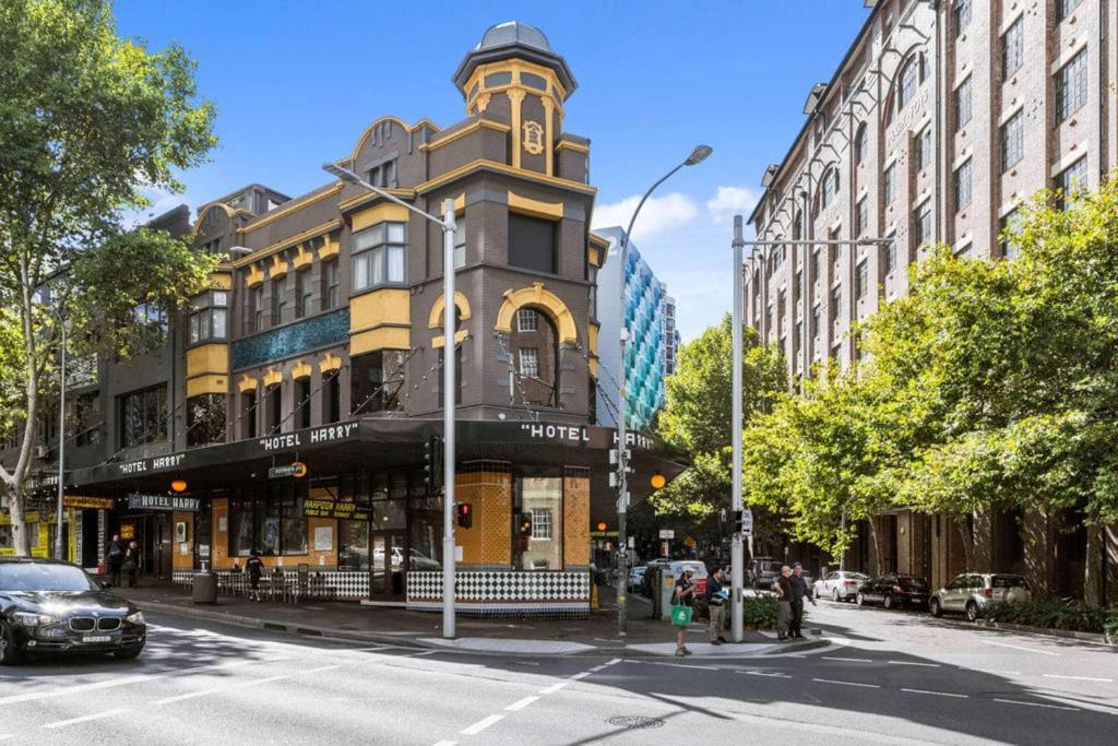 a tall building with a clock tower on a city street at Hotel Harry, an Ascend Collection Hotel in Sydney