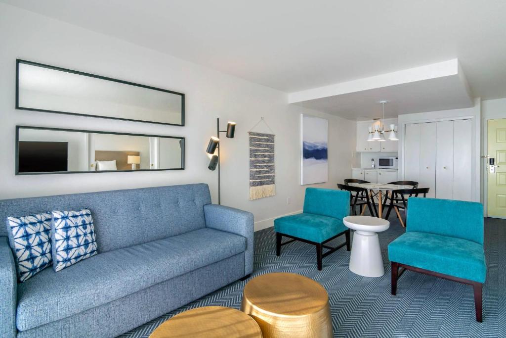 a living room with a blue couch and chairs at Bayside Resort, an Ascend Collection Resort in Parksville