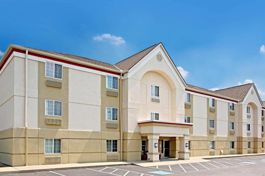 a large building with a parking lot at MainStay Suites Cincinnati Blue Ash in Blue Ash