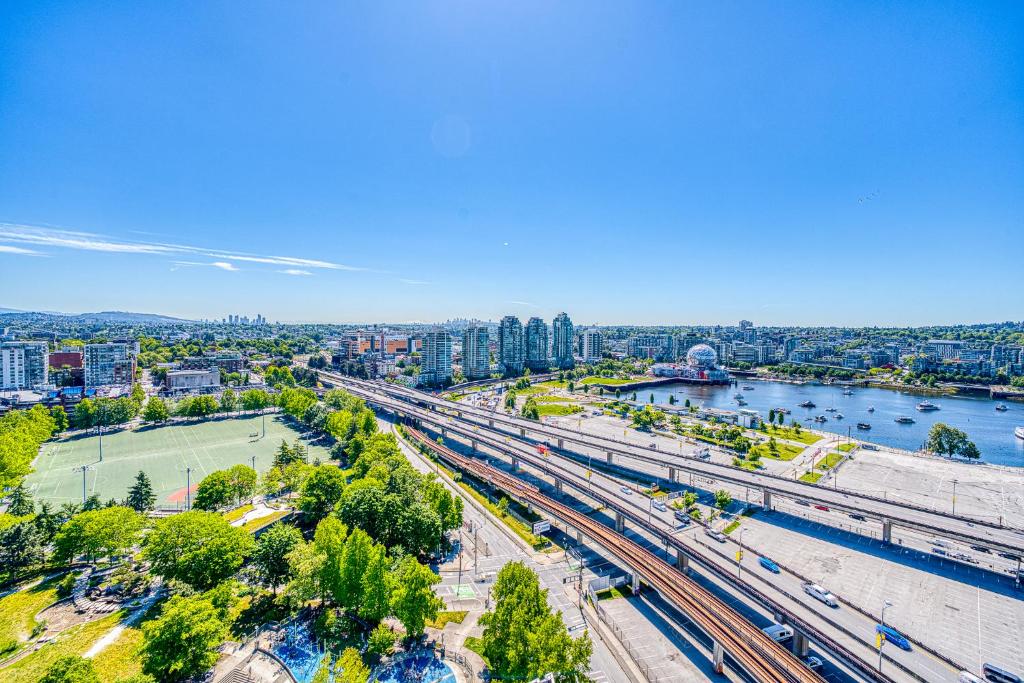 eine Draufsicht auf eine Stadt mit einem Fluss und Bahngleisen in der Unterkunft Central City Location, Bay View, One Free Parking in Vancouver