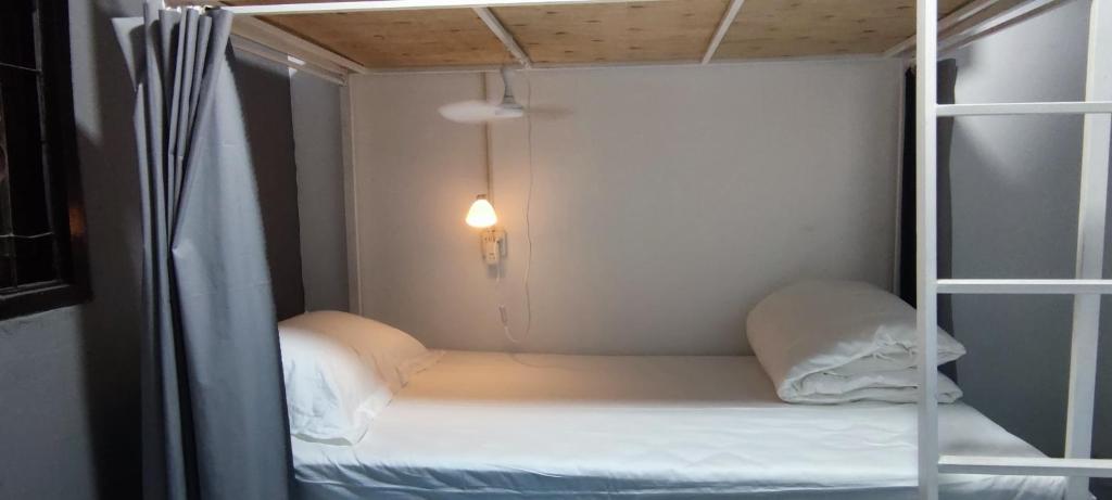 a small room with a bunk bed and a light at OK hostel in Luang Prabang