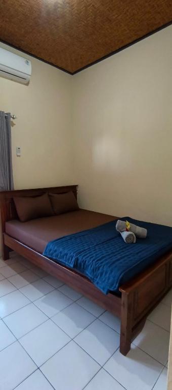 a bed in a room with a blue bedsheet at marvin's guesthouse in Lovina