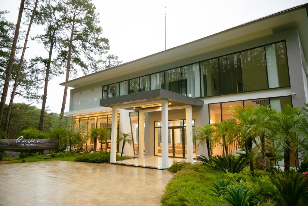 Haven in the Pines في Ðinh An (2): مبنى كبير شبابيكه زجاجيه ونخل