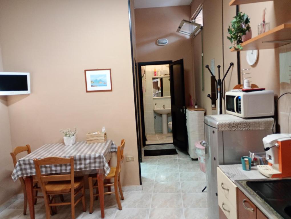 a kitchen with a table with chairs and a microwave at Mini appartamento a Marcianise in Marcianise