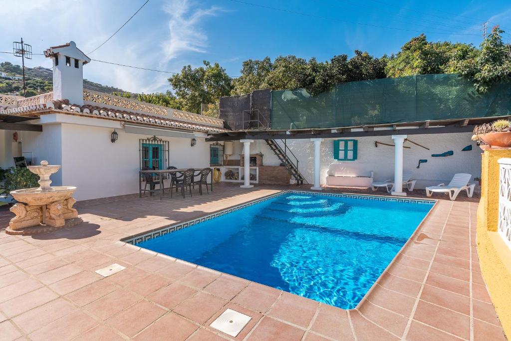 a villa with a swimming pool in front of a house at Casa adelfas in Granada