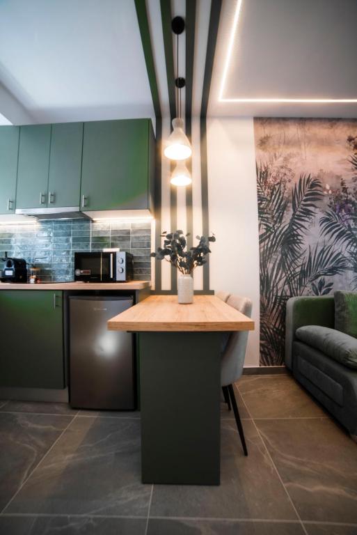 a kitchen with green cabinets and a table with flowers on it at Coloris Viridis room in Thessaloniki