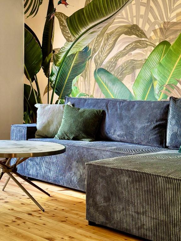 a living room with a blue couch and a table at Garden Eden & Sauna in Neumagen-Dhron