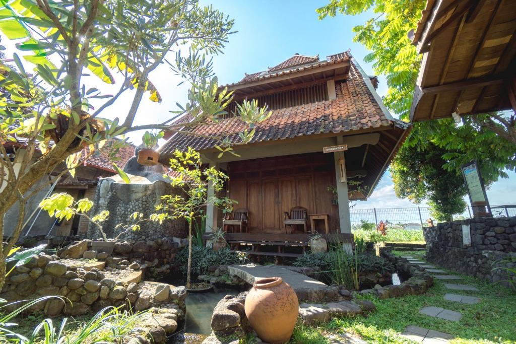a small house with a garden in front of it at Tembi - Historical Home in Yogyakarta