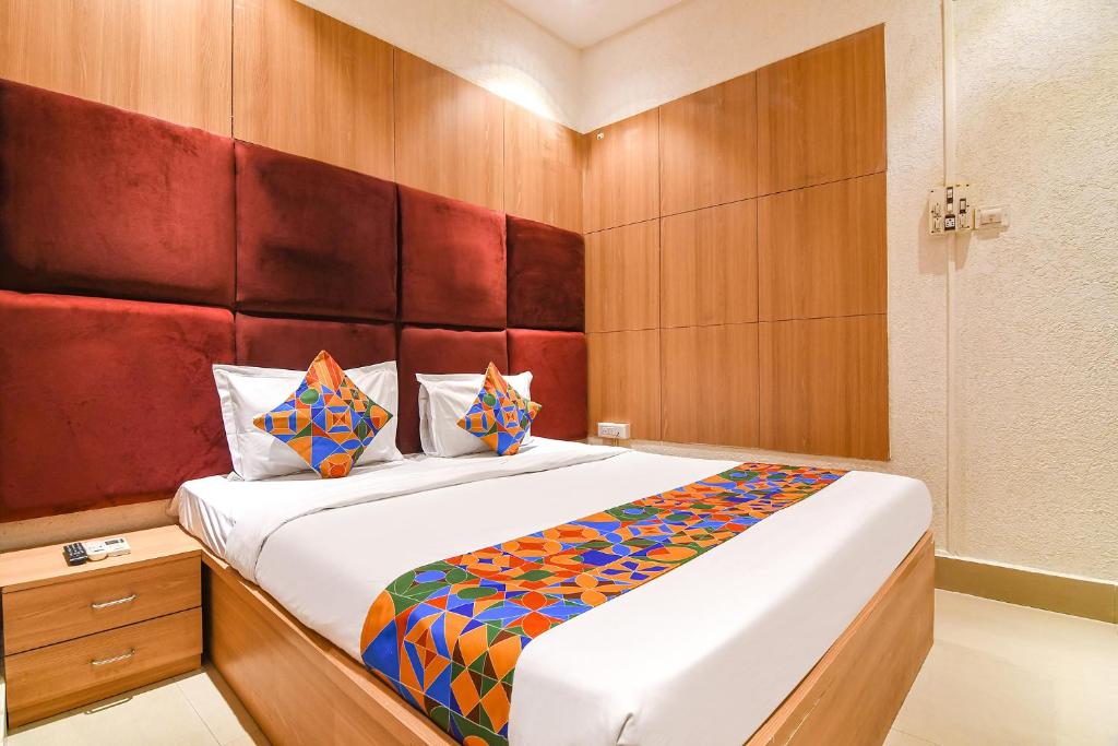 a bedroom with a large bed with wooden walls at FabHotel Marina in Tangra