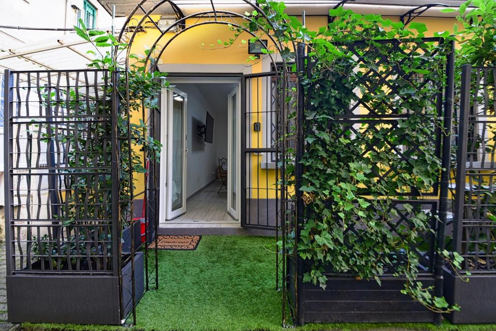 ein Eingang zu einem Haus mit einem offenen Tor mit Pflanzen in der Unterkunft Dream Suites Sesto Centro in Sesto San Giovanni
