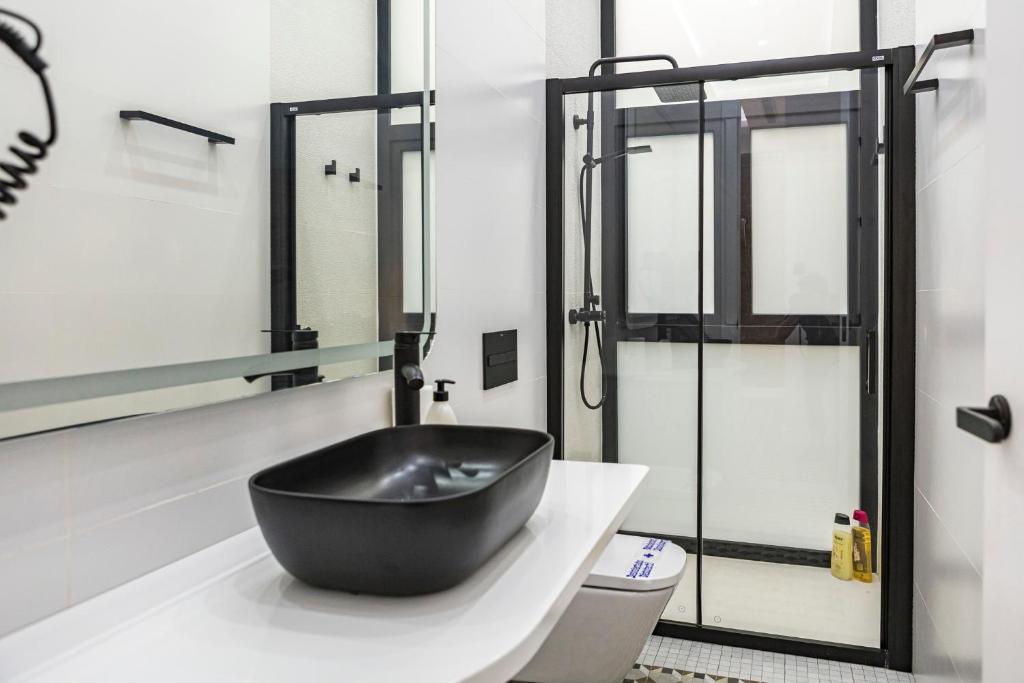 a bathroom with a black sink on a counter at NOMADIA en Plaza de la Constitucion 1 in Málaga