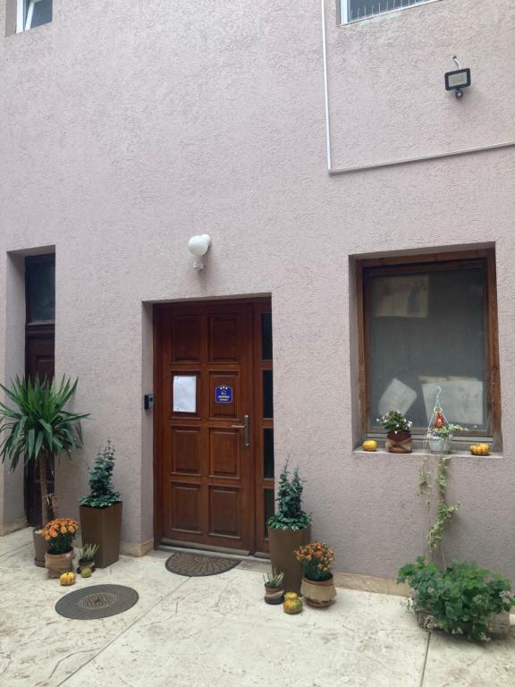 une porte d'un bâtiment avec des plantes en pot devant dans l'établissement Kapetan-Misa, à Belgrade
