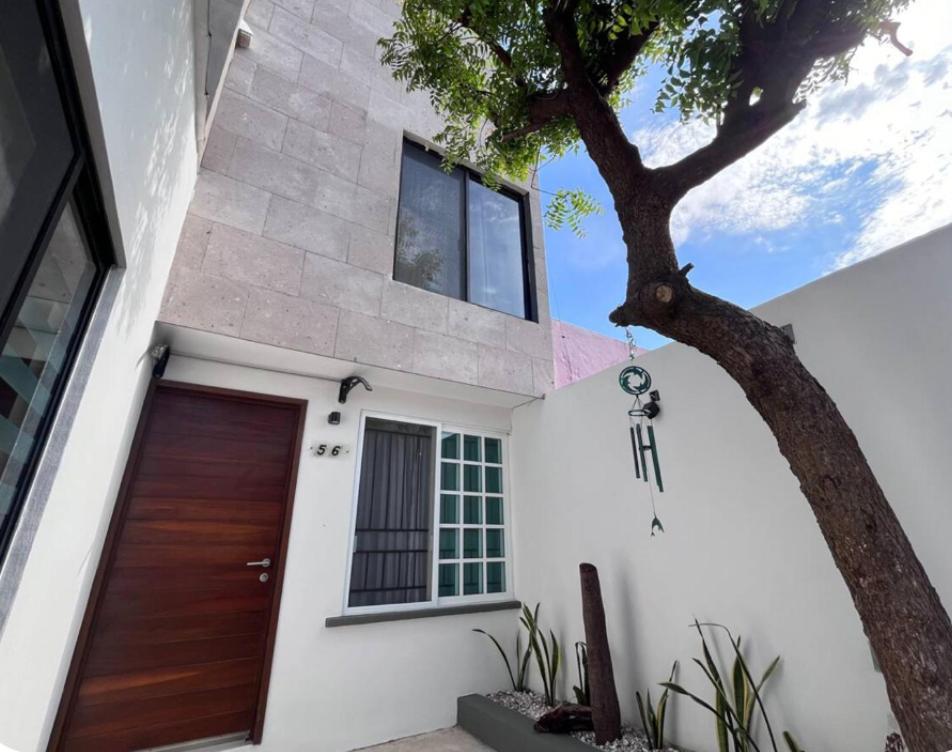 a house with a wooden door and a tree at Casa villas del invernadero in Veracruz