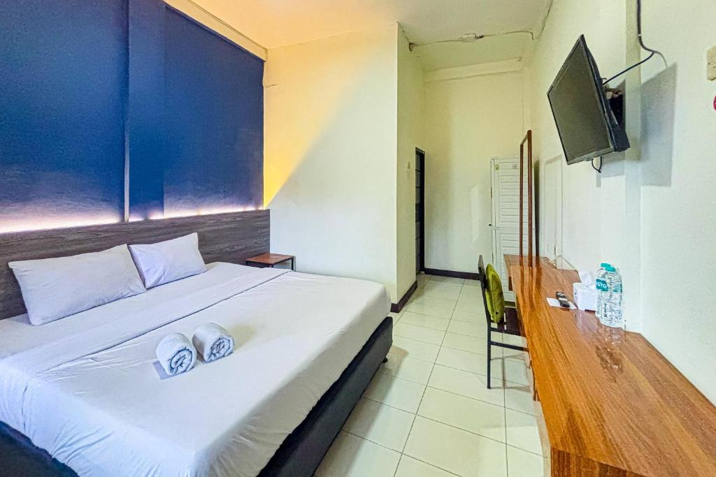 a bedroom with a bed with two pillows on it at Garden View near Batu Tulis RedPartner in Bogor