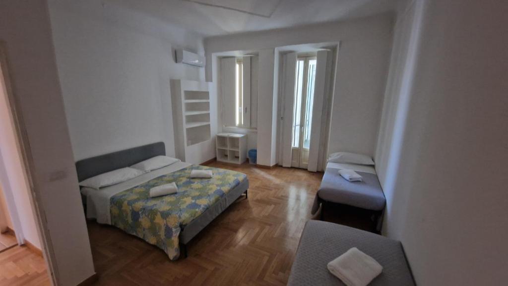 a small room with two beds and a chair at Lilly Home in Milan