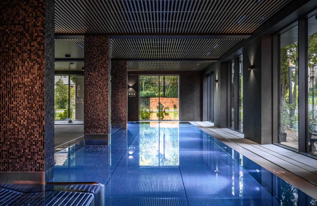 a swimming pool in a building with blue tiles at Polanica Park in Polanica-Zdrój