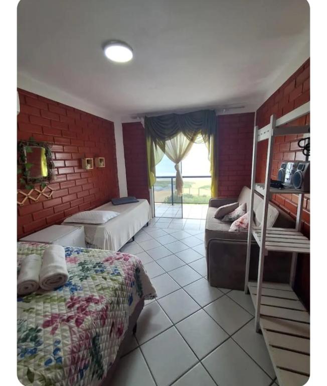 um quarto com duas camas e uma parede de tijolos em Quarto frente mar com sacada! em Barra Velha