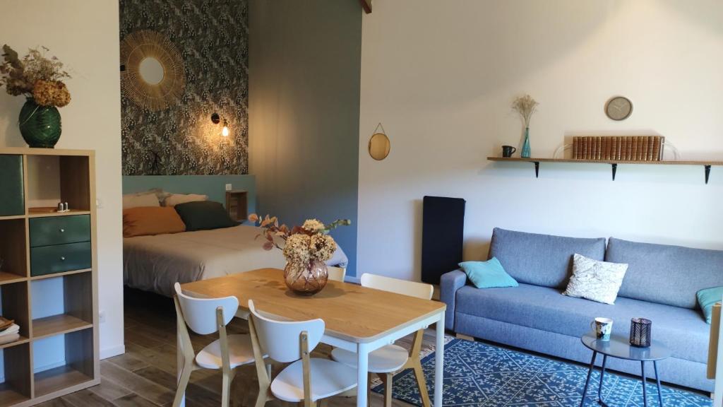 een woonkamer met een tafel en een bank bij Studio Grimm - Tiny House in Le Cellier