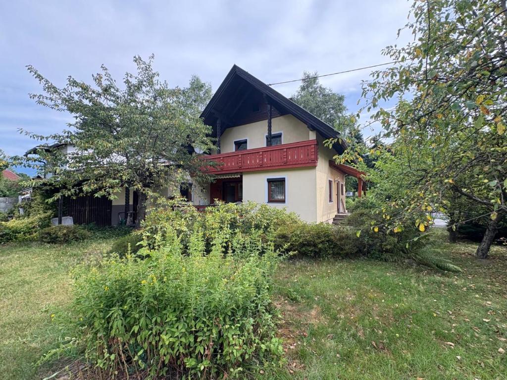 a house on a hill with trees and grass at Capybara Guest House in Spittal an der Drau