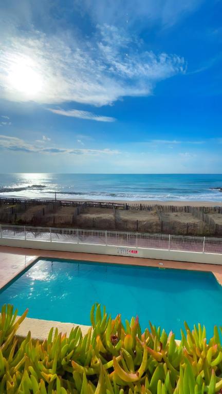 a view of a swimming pool and the ocean at Appartement première ligne vue mer in Aresquies