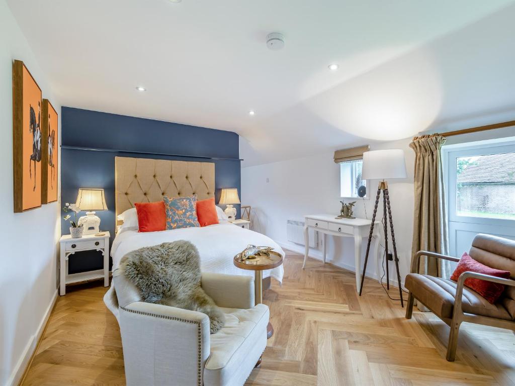 a bedroom with a large white bed and a chair at The Studio in Wittersham