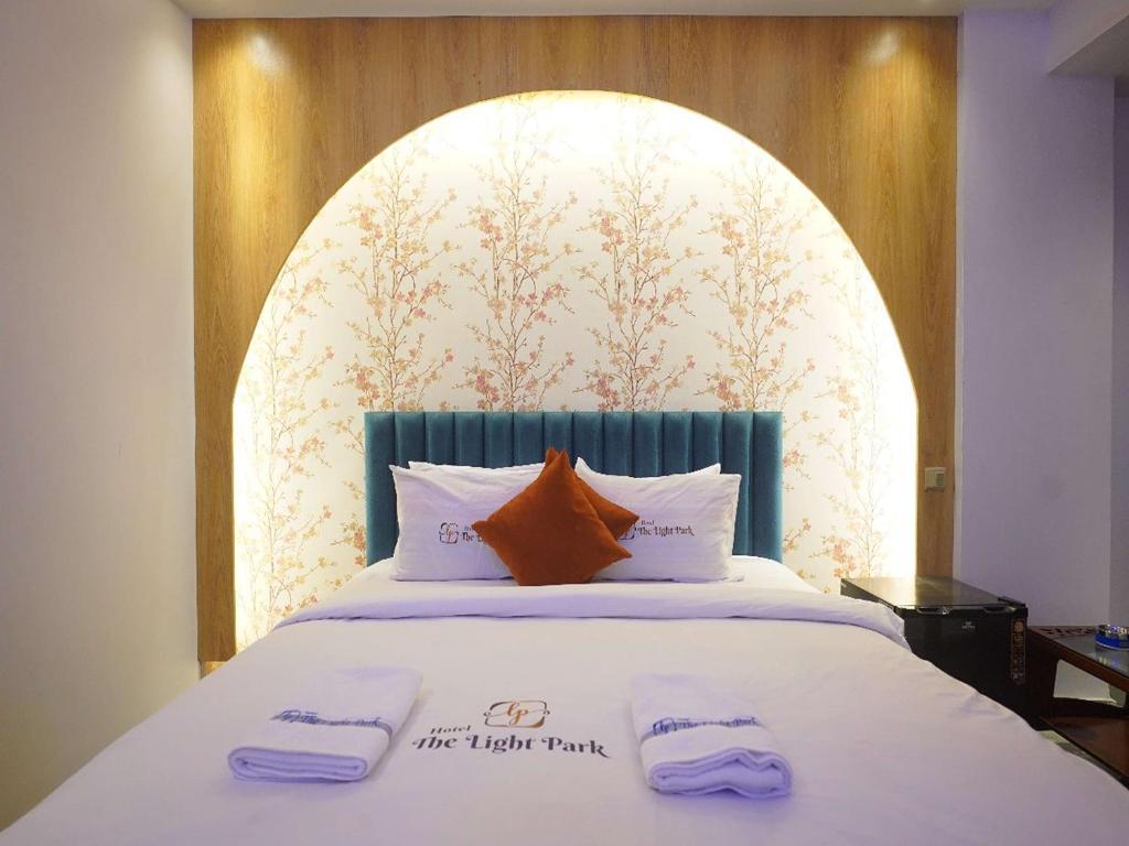 a bedroom with a bed with two towels on it at Hotel The Light Park in Chittagong