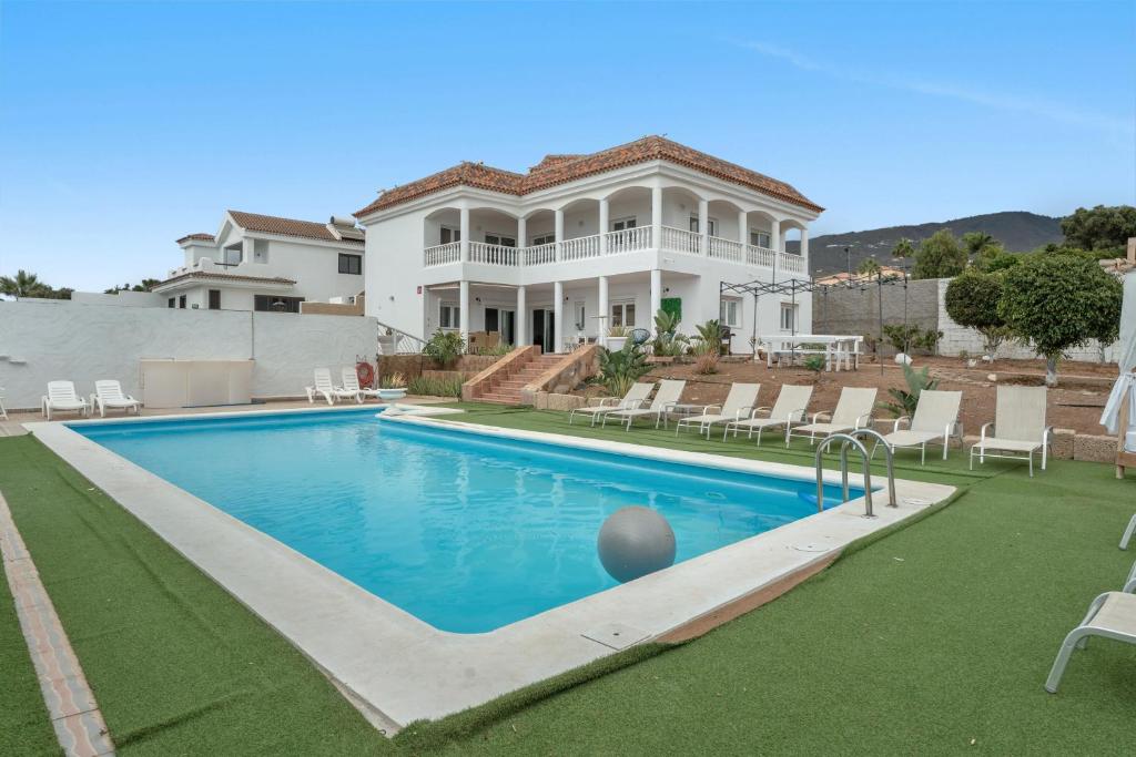 una grande casa con una piscina di fronte di Villa Luxury el Mirador ad Adeje