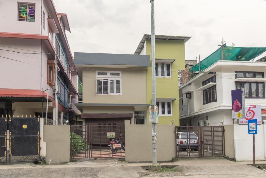 a row of houses on a street with a gate at Tusti Homestay in Guwahati