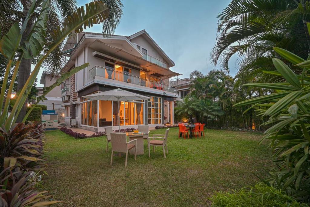una casa con tavolo e sedie nel cortile di Golden Villa 4 Bhk With Private Swimming Pool Centrally Located a Lonavala