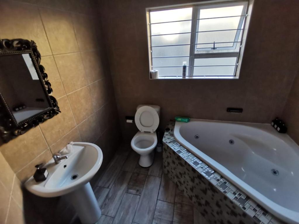 Un baño con bañera, inodoro y lavabo. en Cosy 3 bedroom, en Cape Town