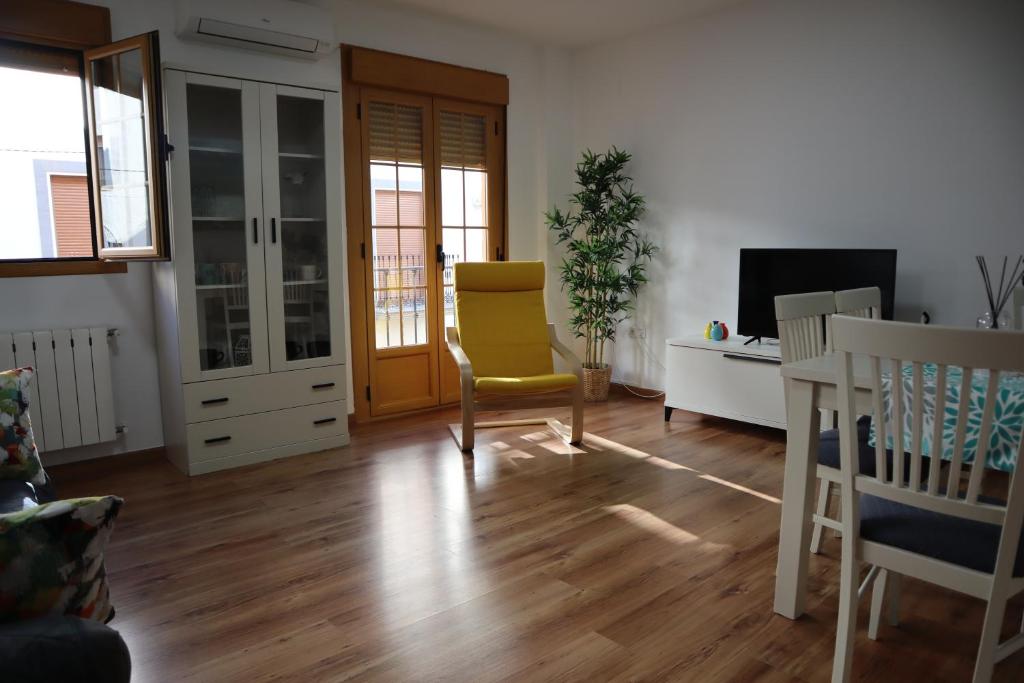sala de estar con silla amarilla y TV en Fleur de Lis apartament, en Huéscar