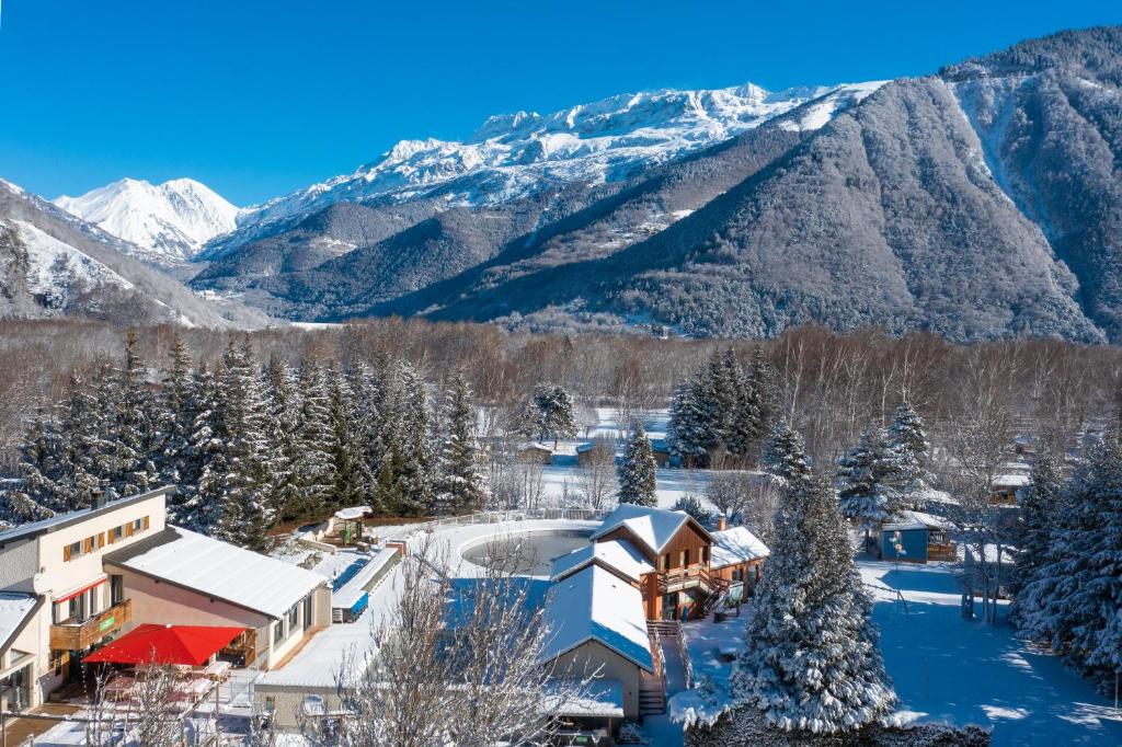 un complejo con montañas cubiertas de nieve en el fondo en Camping RCN Belledonne, en Le Bourg-dʼOisans