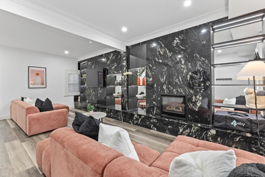 a living room with a couch and a fireplace at Modern 3BR Glebe Home with Terrace & Garage for 8 in Sydney