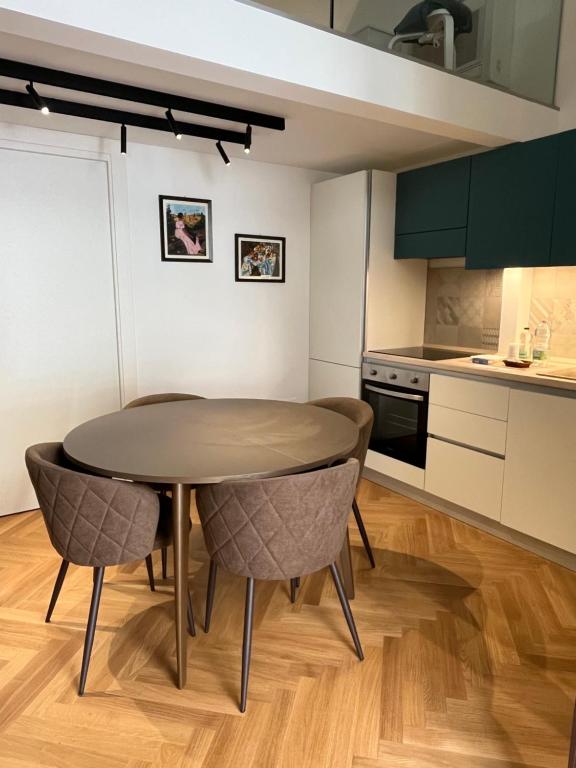 een keuken met een tafel en stoelen in een kamer bij Loft Green Trani in Trani