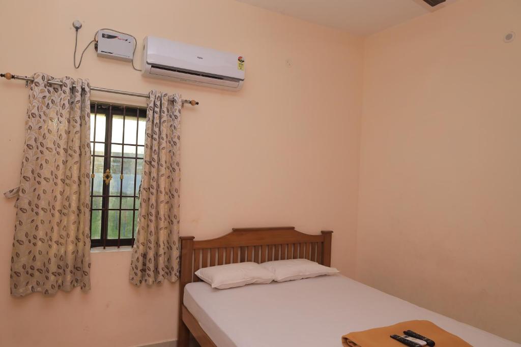 a small bedroom with a bed and a window at Magesh Residency in Jāmb